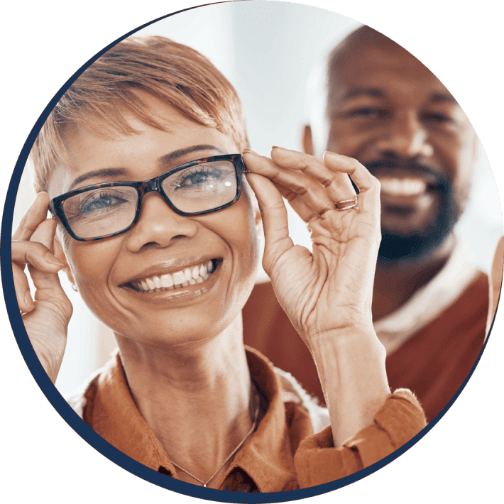 A woman with glasses and a man smiling.