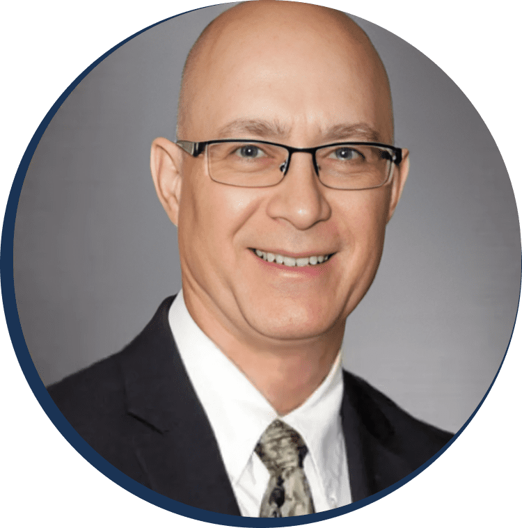 A man in suit and tie with glasses.